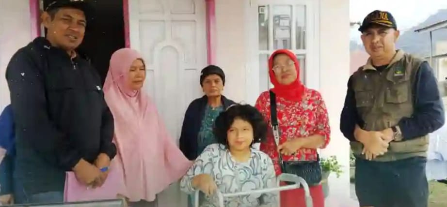 Andini saat menerima alat bantu untuk berjalan dari DSPPKBPPPA Padang Panjang .